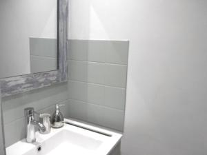 a white bathroom with a sink and a mirror at Maison 4 pièces 5 personnes à 200 m de la plage - MAIANN in Sarzeau