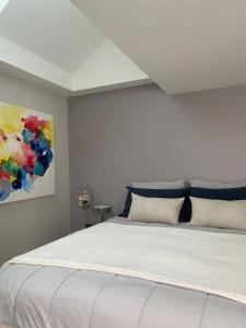 a white bed in a room with a painting at Loft Bellamy in Nantes