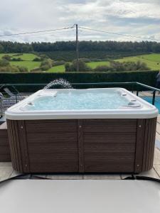 a hot tub sitting on top of a deck at Contemporary Villa in Wellin with Private Pool in Wellin