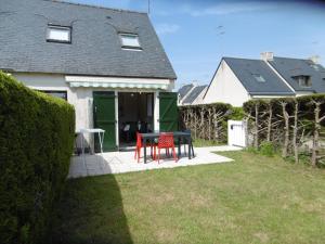 a table and two chairs in the yard of a house at Maison 4 pièces 5 personnes à 200 m de la plage - MAIANN in Sarzeau