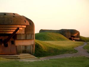 a building on top of a grassy hill at Le Chalet, les pieds dans l'eau in Asnelles