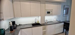 a kitchen with white cabinets and a sink at Apartment in seaside Helsinki 83M2 with Sauna boat to Estonia 450 m from apartment in Helsinki