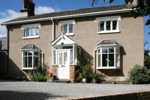 a brick house with a white door and windows at The Old Rectory Bed and Breakfast in Ruthin