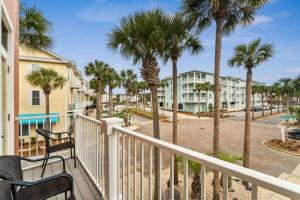 a balcony with palm trees and condos at Rockaway Beach in Santa Rosa Beach
