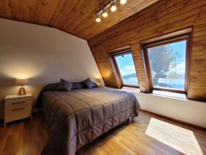 a bedroom with a bed in a room with windows at Destinar Apartments in San Carlos de Bariloche +38 photos