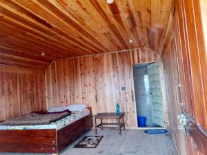 a wooden room with a bed and a table in it at Adithyanaman Cottage Homestay in Darjeeling +7 photos