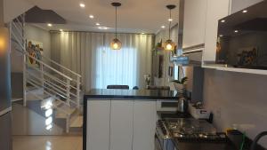 a kitchen with white cabinets and a counter top at Casa linda, luxo e aconchegante in Blumenau