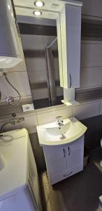 a bathroom with a sink and a mirror at Cozy Modern Apartment in Gevgelija