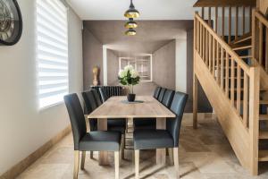 a dining room with a wooden table and black chairs at "Le 35" Maison rénovée avec jardin proche centre in Lamotte-Beuvron