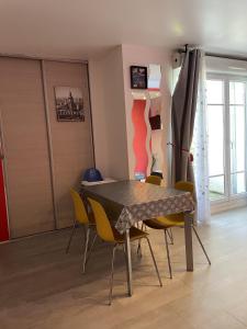 a dining room with a table and yellow chairs at 15 min walk to DisneylandParis, 5 min walk to Val d'Europe Mall and train RER A, Monyhome apartment for 4 persons in Chessy +9 photos