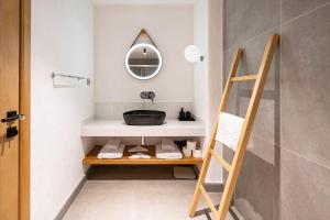 a bathroom with a sink and a wooden shelf at Nomad Hotel Side - Adults Only in Side +141 photos