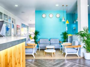 a waiting room with chairs and a blue wall at Coral Compostela Beach Golf in Playa de las Americas +92 photos