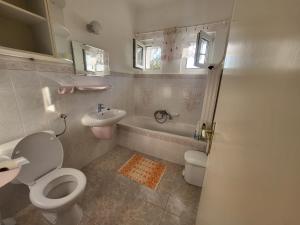 a bathroom with a toilet and a sink and a tub at Erika Apartman in Balatonlelle +9 photos