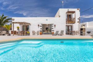 eine Villa mit einem Swimmingpool vor einem Haus in der Unterkunft Bodega Botanica - Shared Pool - Central Island Location - 10 mins drive to Famara and La Santa in Tiagua + 18 Fotos