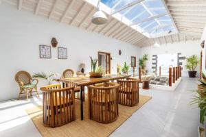ein offenes Wohnzimmer mit einem Holztisch und Stühlen in der Unterkunft Bodega Botanica - Shared Pool - Central Island Location - 10 mins drive to Famara and La Santa in Tiagua