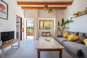 ein Wohnzimmer mit einer Couch und einem Couchtisch in der Unterkunft Bodega Botanica - Shared Pool - Central Island Location - 10 mins drive to Famara and La Santa in Tiagua