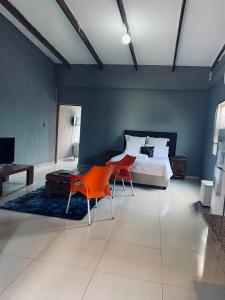 a bedroom with a bed and two chairs and a table at Onothweni Lodge in Manguzi