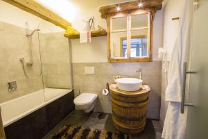 a bathroom with a sink and a toilet and a tub at Chalet Da Mont in Selva di Val Gardena