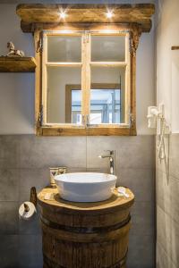 een badkamer met een grote witte wastafel op een houten tafel bij Chalet Da Mont in Selva di Val Gardena