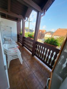 a porch with chairs and tables on a balcony at Erika Apartman in Balatonlelle