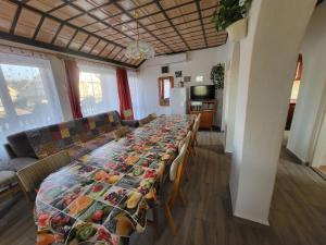 a long table in a living room with a table cloth at Erika Apartman in Balatonlelle