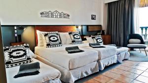 a hotel room with two beds and a chair at Coral Cotillo Beach in El Cotillo