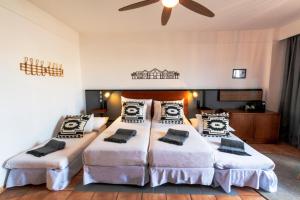 a bedroom with two beds and a ceiling fan at Coral Cotillo Beach in El Cotillo
