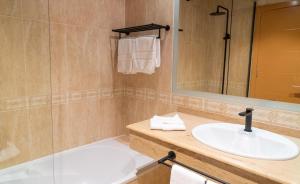 a bathroom with a sink and a mirror at Coral Cotillo Beach in El Cotillo