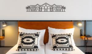 a bedroom with a bed with black and white pillows at Coral Cotillo Beach in El Cotillo
