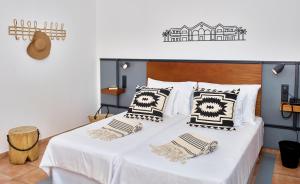 a bedroom with a white bed with black and white pillows at Coral Cotillo Beach in El Cotillo