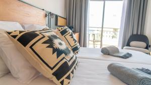 a bedroom with a bed with pillows and a window at Coral Cotillo Beach in El Cotillo