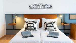 two beds with black and white pillows in a room at Coral Cotillo Beach in El Cotillo
