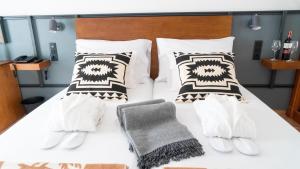 a bedroom with a white bed with black and white pillows at Coral Cotillo Beach in El Cotillo