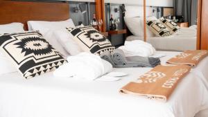 two white beds with pillows and towels on them at Coral Cotillo Beach in El Cotillo