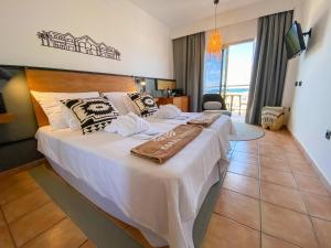 a bedroom with a large bed with white sheets and pillows at Coral Cotillo Beach in El Cotillo