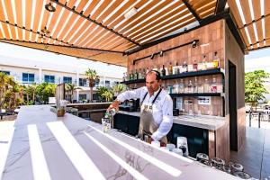 a bartender making a drink at a bar at Coral Cotillo Beach in El Cotillo