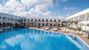 a large swimming pool in front of a building at Coral Cotillo Beach in El Cotillo