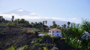 a house on a hill with a mountain in the background at Coral La Quinta Park Suites in Santa Úrsula +116 photos