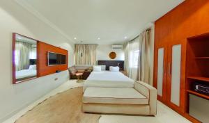 una camera da letto con un letto, un divano e una TV di C apartment ad Abuja