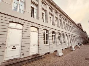 una fila de puertas blancas en un edificio en Studio Tintin, en Bruselas