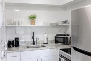 Una cocina blanca con fregadero y microondas. en Sojourn Bayside 2 Bedroom, en Norfolk