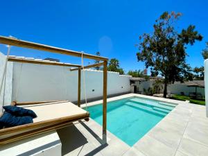 a swimming pool with a swing next to a house at Minichalet El Molino 5 in Chiclana de la Frontera