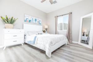 a white bedroom with a white bed and a window at Comfy and Stylish 4 Bathrooms 26 in Ridgecrest