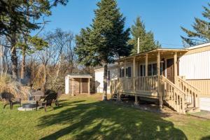a house with a porch and chairs in the yard at Stylish and Spotless Beach Getaway in Grayland