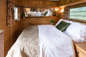 a bedroom with a white bed in a room at Beach Get Away Fabulous Vintage Trailer in Grayland