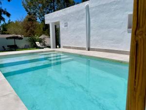 a swimming pool with blue water in front of a white building at Minichalet El Molino 5 in Chiclana de la Frontera