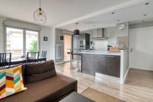 a living room and kitchen with a couch and a counter at L'Arène de coeur - appt avec piscine partagée in Toulouse