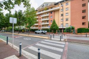an empty street in front of a building at L'Arène de coeur - appt avec piscine partagée in Toulouse