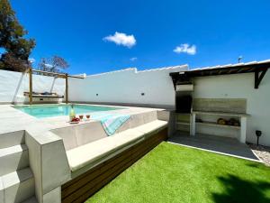 a backyard with a swimming pool and green grass at Minichalet El Molino 5 in Chiclana de la Frontera +29 photos