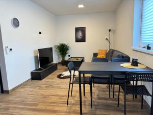 a living room with a table and chairs and a couch at j ONE Apartmány in Pardubice +5 photos